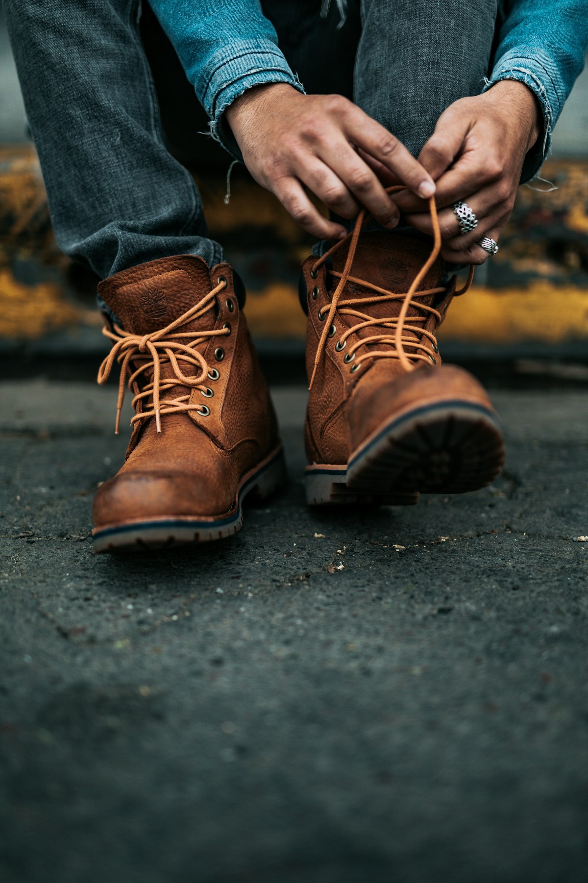 Hände schnüren braune Lederstiefel